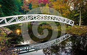 Autumn color and walking bridge over a pond in Somesville, Maine