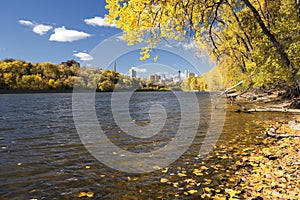 Autumn colors along the Mississippi River, Minneapolis skyline in the distance.