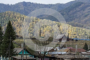 Autumn colors of the Altai mountain. Village among the autumn hills