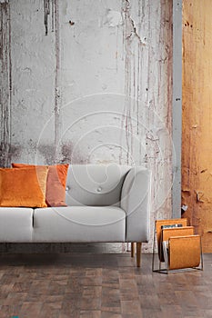 Autumn colors in wabi sabi living room interior with shabby wall and new stylish couch and magazine rack photo