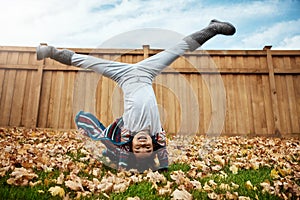 When autumn comes so does the leaf crunching fun. an adorable little girl doing cartwheels an autumn day outdoors.