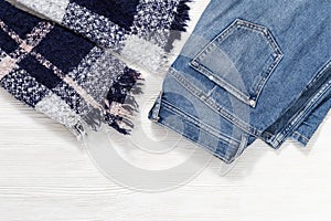 Autumn comfortable clothes. Warm cozy scarf, blue denim jeans. Casual fashion outfits
