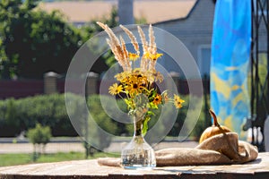 Autumn composition of a bouquet of yellow flowers in combination with dry grass