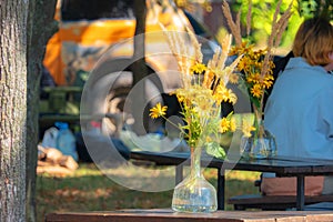 Autumn composition of a bouquet of yellow flowers in combination with dry grass