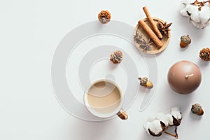 Autumn composition with coffee cup, acorns, candle, cotton on white background. Flat lay, top view. Nordic, hygge, cozy home