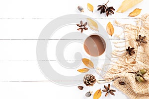 Autumn composition. Cup of coffee, blanket, autumn leaves on white wooden background. Flat lay, top view copy space