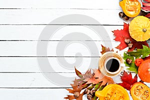 Autumn composition: A cup of coffee and colored autumn leaves. flat lay. On a white wooden background.