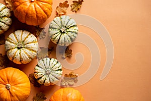 Autumn composition. Flat lay pumpkins, fallen oak leaves on vintage orange background. Thanksgiving day greeting card template