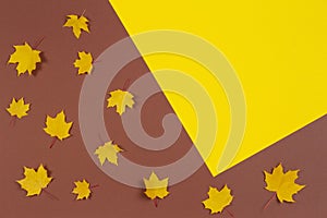 Autumn composition. Frame made of autumn maple leaves on brown and yellow background