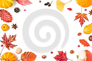 Autumn composition. Frame made of fall leaves, pumpkins, flowers, berries, quince, nuts on white background