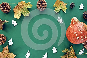 Autumn composition. Frame made of Pumpkins,dried leaves and decorative ghoasts background. Template autumn, fall, halloween,