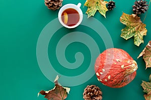 Autumn composition. Frame made of Pumpkins,dried leaves, pine cones and tes cup background. Template autumn, fall, halloween,