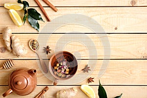 Autumn composition with fruit tea cup, teapot, autumn leaves, cinnamon sticks, anise star, spoon of dried team, lemon, ginger root