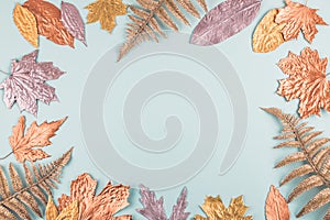 Autumn composition with golden leaves frame on blue pastel background. Fall mockup with gold maple leaves. Flat lay, top view,