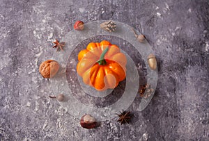 Autumn composition with pampkin, nuts and spices on the gray table. Circle shaped. Autumn concept. Minimalism