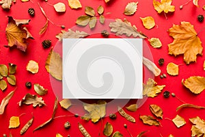 Autumn composition with paper blank and dried leaves on table. Flat lay, top view, copy space