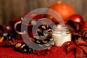 Autumn composition. A pinecone, a candle and tea on the table. Ingathering