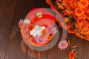 Autumn composition of pumpkins and flowers on a brown background. Blur, selective focus. autumn card , copy space