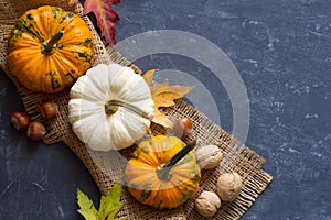 Autumn composition of pumpkins, leaves and nuts on dark background, concept of Thanksgiving day