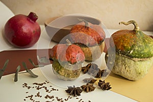 Autumn composition with pumpkins, spices, anis stars, linen, eucalyptus, pomegranate and wooden plate. Halloween theme