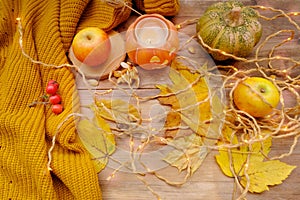 Autumn composition on rustic wooden table in garden with pumpkin, fallen yellow, orange leaves and berries, concept happy