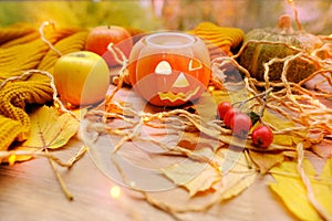 Autumn composition on rustic wooden table in garden with pumpkin, fallen yellow, orange leaves and berries, concept happy