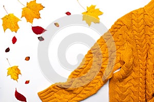 Autumn composition.Warm yellow knitted sweater, leaves on white background. Flat lay, top view,