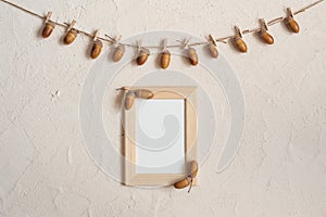 Autumn composition with wooden frame. Acorn with clothespins on clothes line rope. Wooden pegs. Flat lay, top view, copy space.