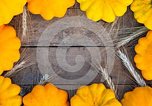 Autumn composition with yellow patissons on an old wooden background. With copy space.