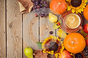 Autumn concept with coffee cup, pumpkin, apples and sunflowers on wooden table. Thanksgiving holiday background. Top view from