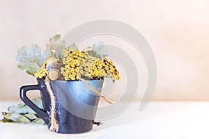 Autumn concept. Dried flowers in a cup. Dried tansy and oak leaves for making herbal tea. Autumn background with copy