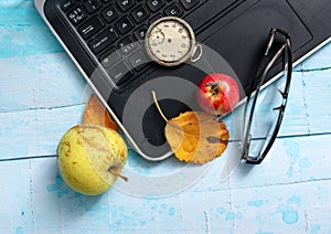 autumn concept, ripe apples, laptop,leaves on blue paint wood surface,top view