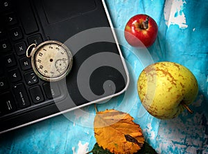 autumn concept, ripe apples, laptop,leaves on blue paint wood surface,top view