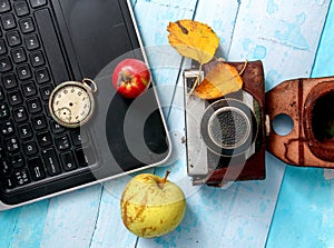 autumn concept, ripe apples, laptop,leaves on blue paint wood surface,top view