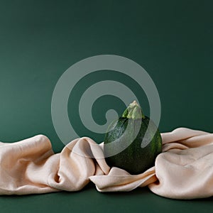Autumn concept of zucchini  on a green background with saten fabric cloth