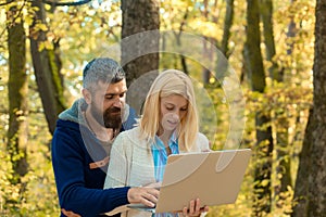 Autumn couple using notebook. Young couple with autumnal mood. Fall concept. Outdoor autumn portrait Gorgeous models