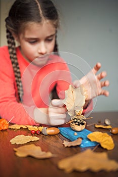 Autumn craft with kids. children`s cute boat with man made of natural materials. process of creating