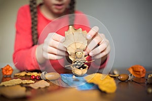 Autumn craft with kids. children`s cute boat with man made of natural materials. process of creating