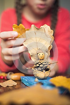 Autumn craft with kids. children`s cute boat with man made of natural materials. process of creating