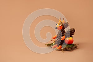 Autumn crafts. Children`s fall crafts and creativity, Squirrel made from modeling clay, cones and nuts on dry stump. Ideas for