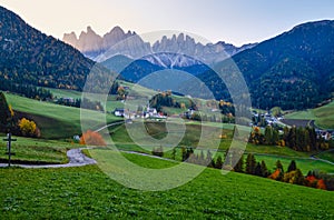 Autumn daybreak Santa Magdalena famous Italy Dolomites village view in front of the Geisler or Odle Dolomites mountain rocks.