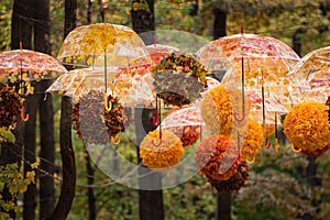 Autumn decor Park. Parasols and flower garlands. Autumn-themed umbrellas