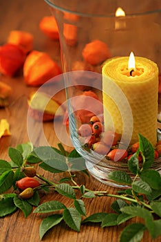 Autumn decoration of rose hips and candle