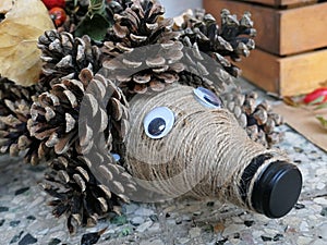 Autumn decorative figure of hedgehog made of plastic flask and pine cones, flask tip as nose