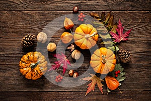 Autumn decorative pumpkins with fall leaves on wooden background. Thanksgiving or halloween holiday, harvest concept. Top view, co