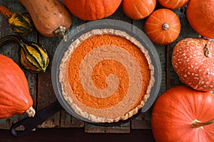 Autumn dessert. Homemade pumpkin pie and raw pumpkins and squash