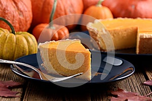 Autumn dessert. Traditional pumpkin pie with bright pumpkins on wooden background rustic style