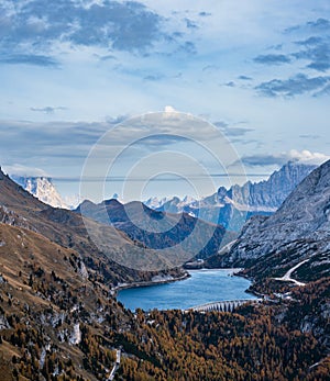 Autumn Dolomites mountain scene from hiking path betwen Pordoi Pass and Fedaia Lake, Italy. Snowy Marmolada Glacier and Fedaia