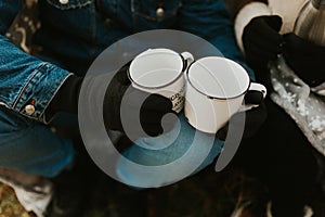 Autumn fall camping mugs with tea. couple drinking hot tea on a forest trail. autumn mugs