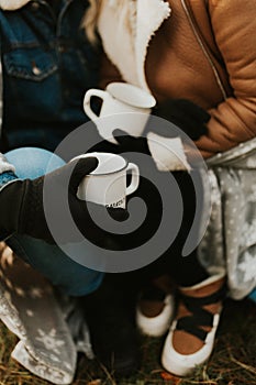 Autumn fall camping mugs with tea. couple drinking hot tea on a forest trail. autumn mugs